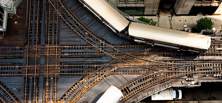 An aerial view of an elevated train crossing in a city displaying unity in photography