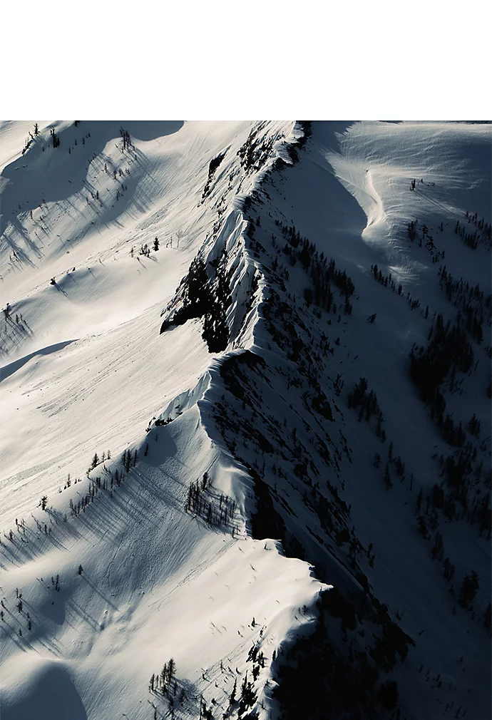 A high-contrast photo of an aerial view of a snow-covered mountain range