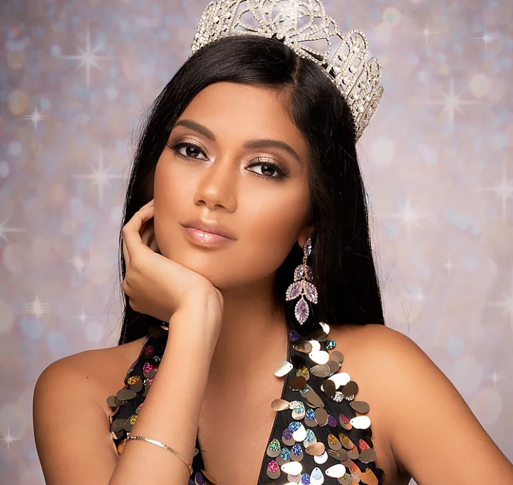 A pageant contestant wearing a tiara crown posing for a portrait photo