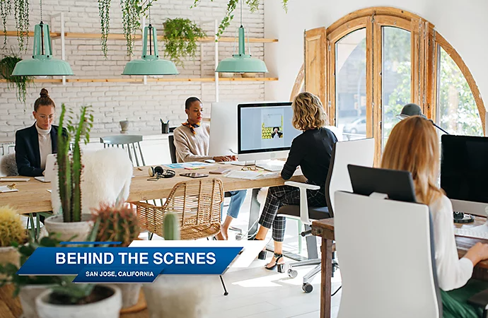 A lower third title superimposed over an image of people working at desks in an office space