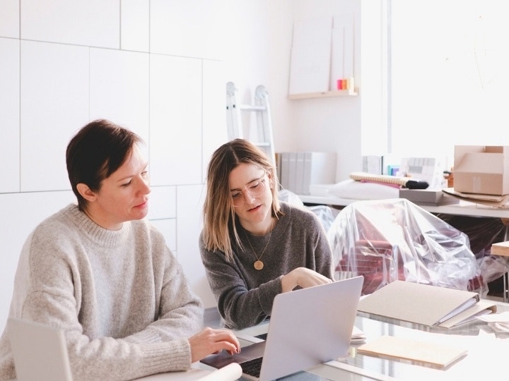 Two small business owners looking over their sourcing documents to streamline the procurement process