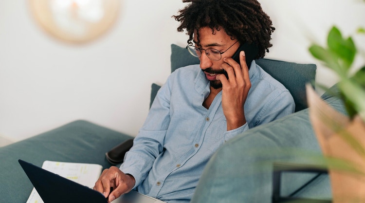 A person reviews an affidavit on their laptop while talking on their phone