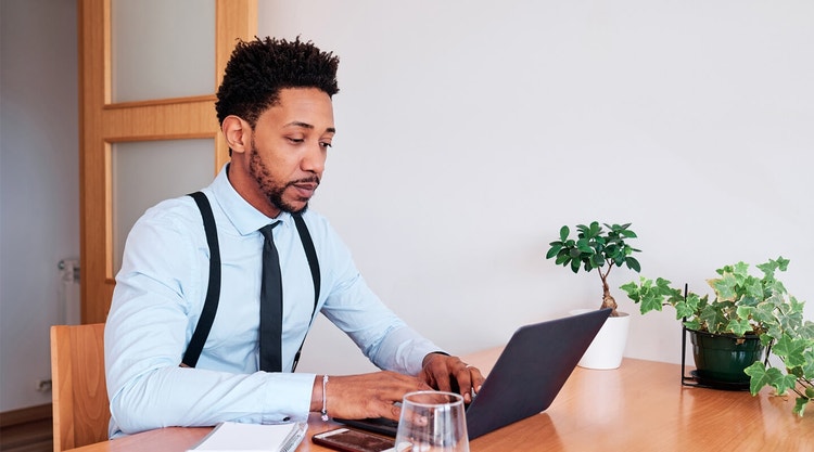 A person sitting at their desk writing a letter of intent to purchase on their laptop