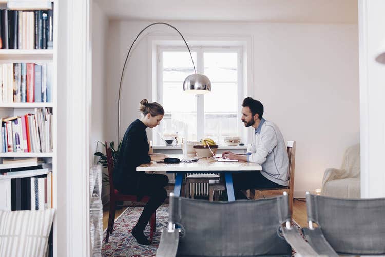 A woman and a man working across a table together on a memorandum of understanding document.