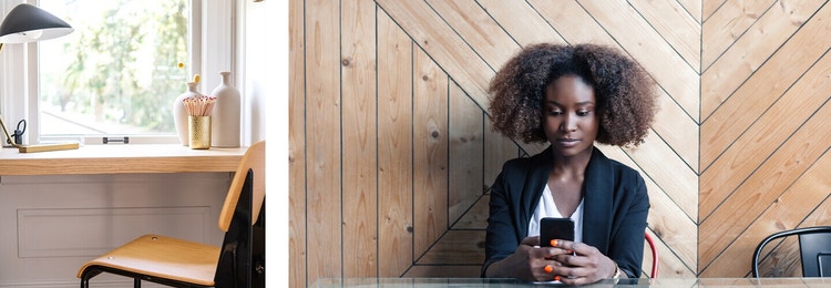 A small desk and a window next to a woman reviewing a memorandum of understanding on their phone