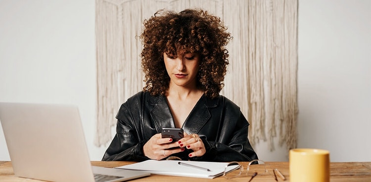 A person using their phone while at their desk