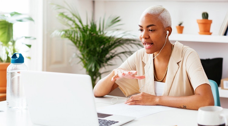 A person sitting at their desk having a video conference with a colleague