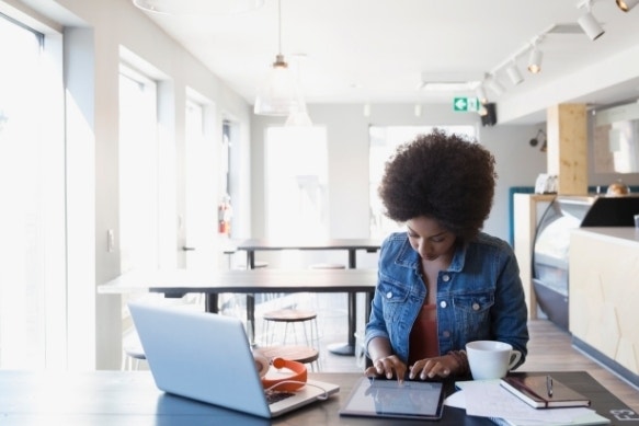 A photo of a person analyzing an itemized receipt on a tablet.