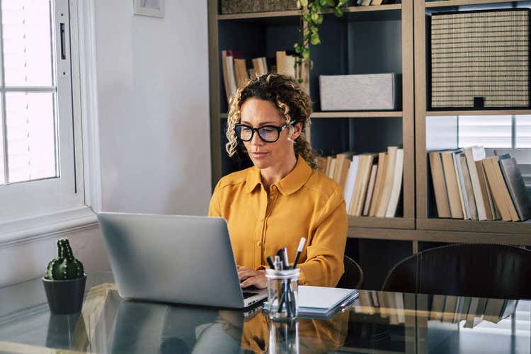 A person sitting in their office working on an affidavit on their laptop