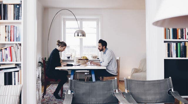 A woman and a man working across a table together on a memorandum of understanding document.