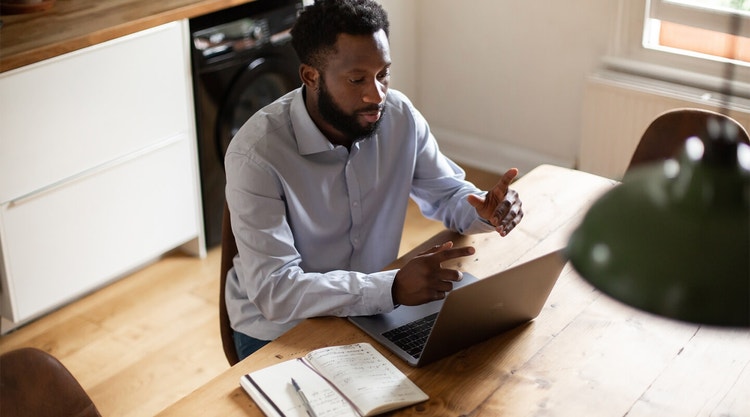 A business person working at a wooden table on their laptop