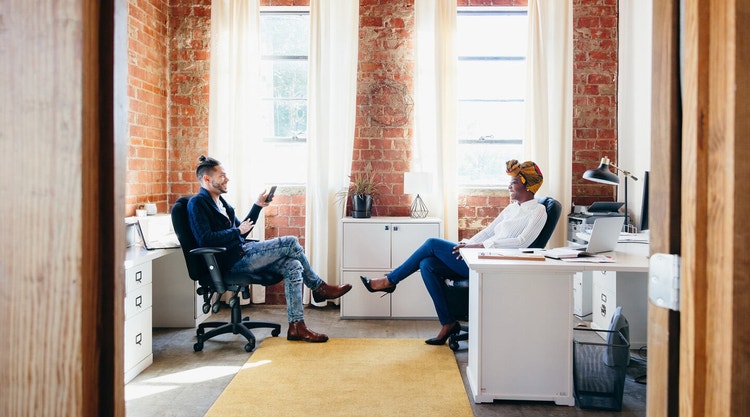 Business colleagues sitting in an office discussing improvements to their sales workflow