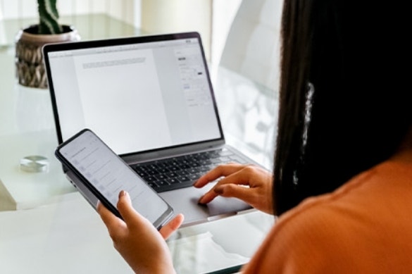 A client multitasks between two digital agreement documents on their phone and laptop