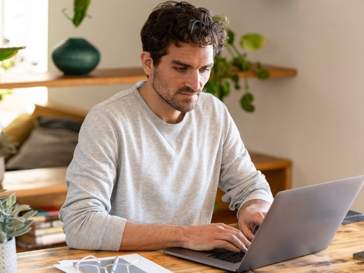 A small business owner working on digitizing their systems of agreement on their laptop using Adobe tools