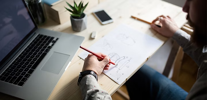 A person sketching modern logo designs at their desk