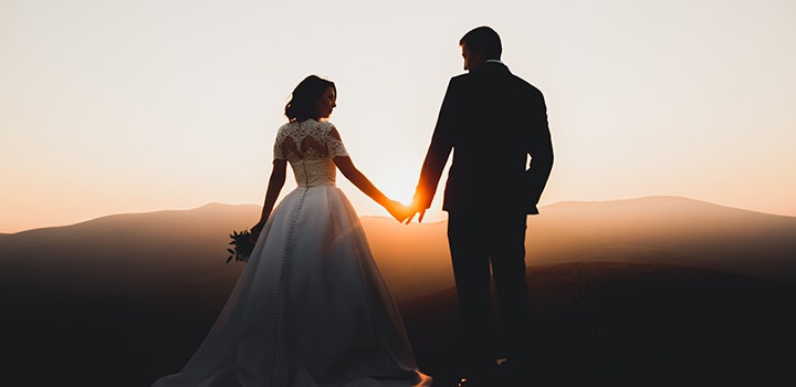 Amazing wedding photo of a bride and groom walking into the sunset.