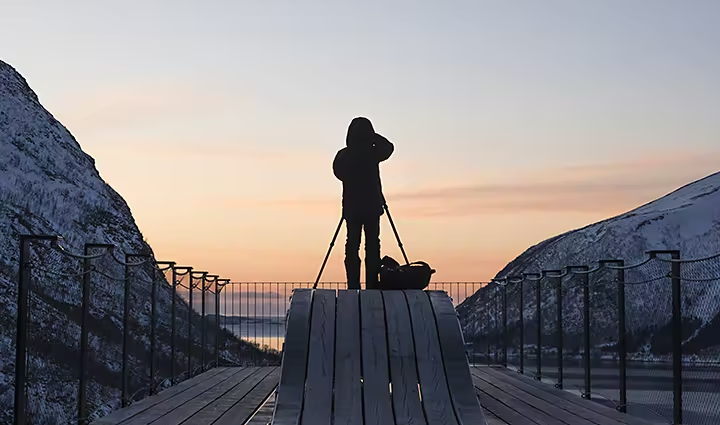 A person capturing a time-lapse of a sunset