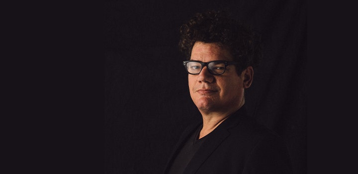 Corporate headshot of a confident man dressed in black