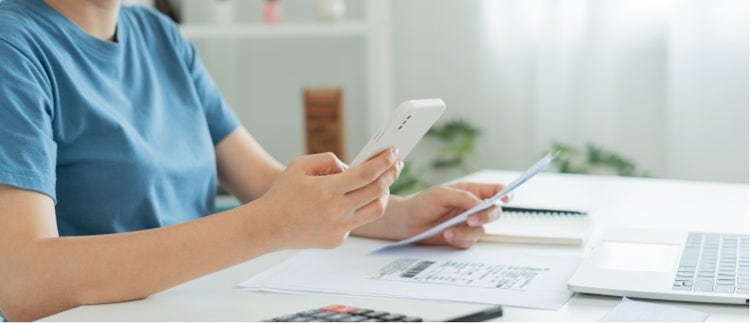 A person at a desk using OCR receipt scanner.