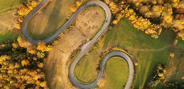 Drone photo of winding road in the autumn countryside.