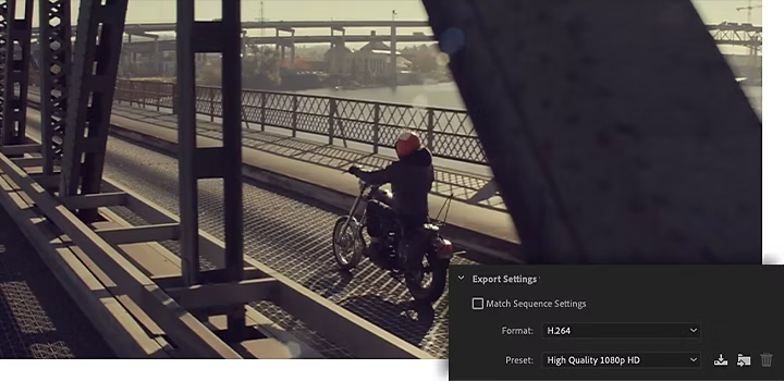 A person riding a motorcycle over a metal bridge