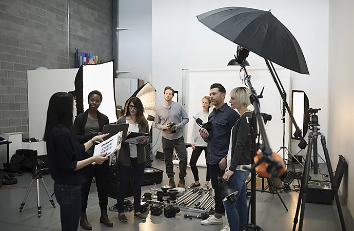 Production crew listening to the producer run through production plans before principal photography