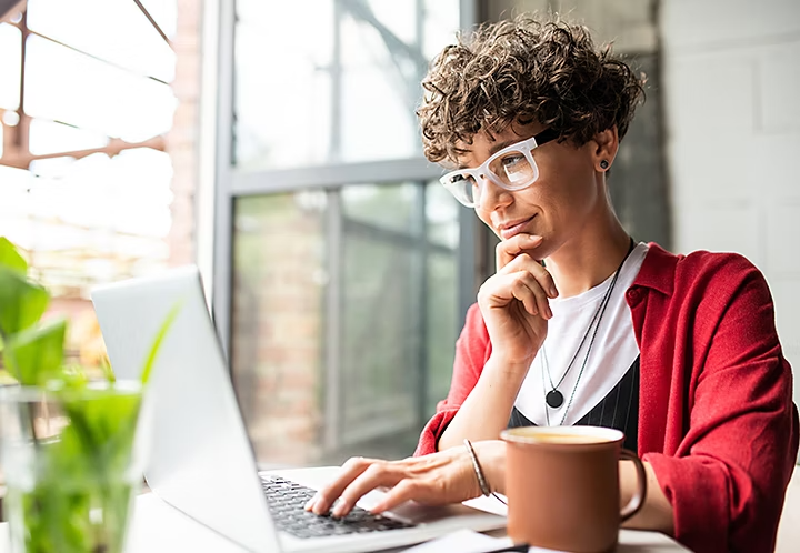 A person sitting at a table using their laptop