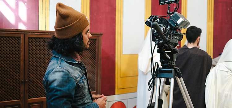 A person setting up a DSLR camera on a production set for principal photography