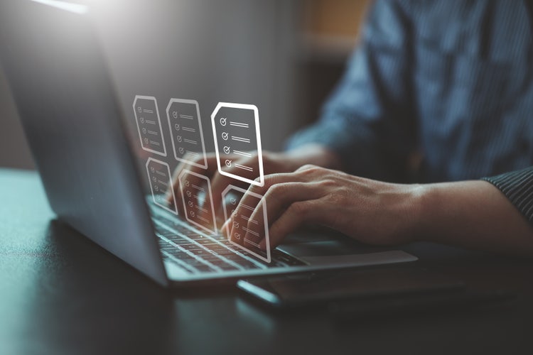 An open laptop on a desk with multiple folders