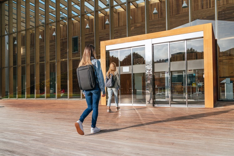 Due studentesse di spalle che entrano in un'università