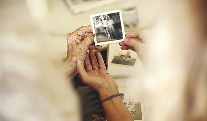 Due persone che tengono in mano insieme una foto in bianco e nero ritoccata