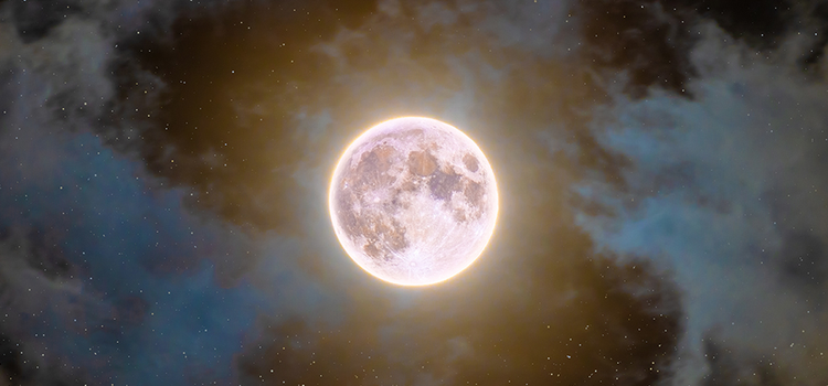 Brilliant full moon and stars captured in a partially cloudy sky