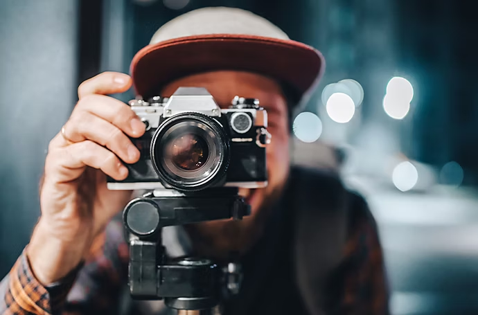 Ragazzo in primo piano mentre scatta una foto con macchina fotografica