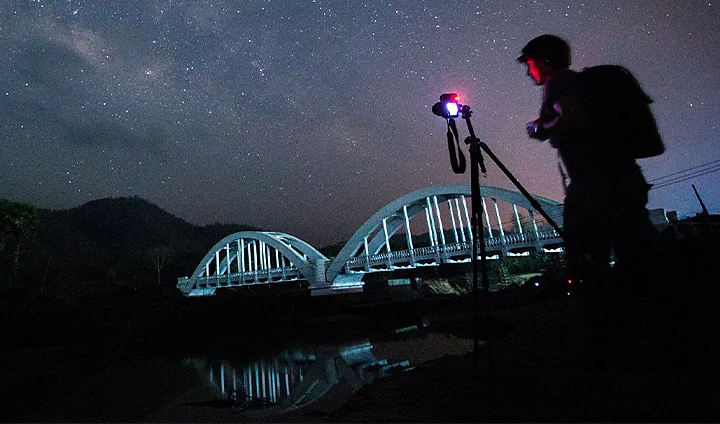 Photographer pointing their camera at the starlit sky