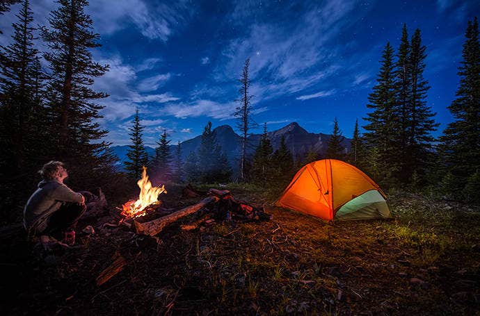 Fotografia notturna di un escursionista accampato in montagna