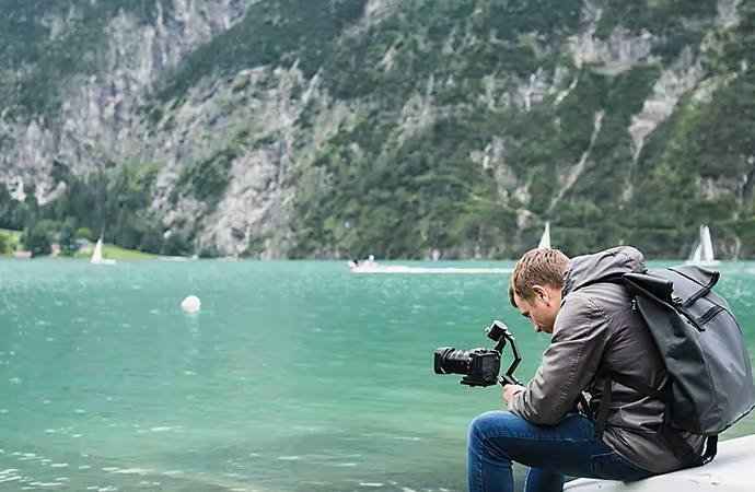 Persona che registra un video sulla riva.