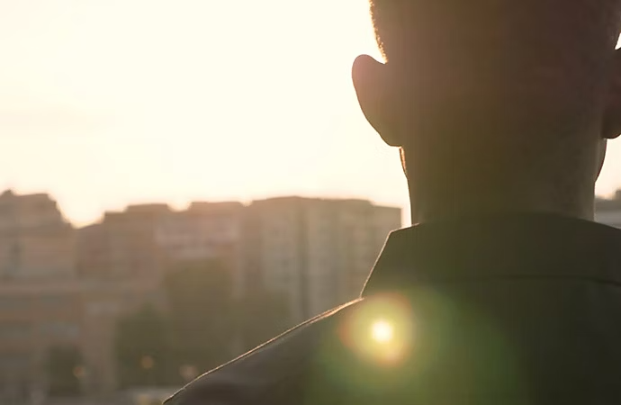 Ripresa sulla spalla di una persona in piedi all’esterno.