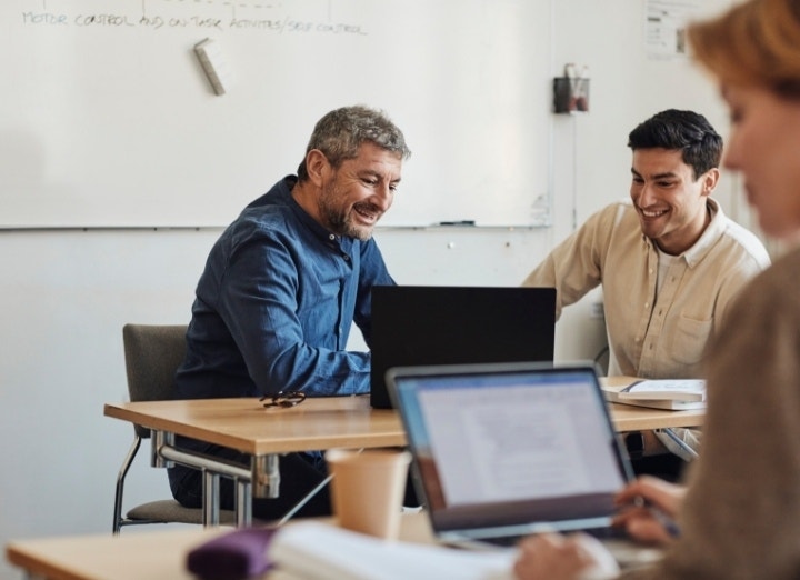 Two people looking over a letter of recommendation and smiling after it has been signed using Adobe Acrobat sign