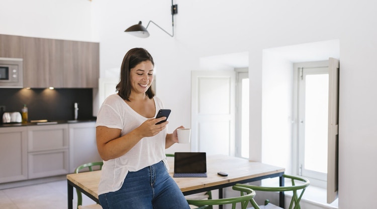 A person standing in their kitchen signing a PDF document on their iPhone