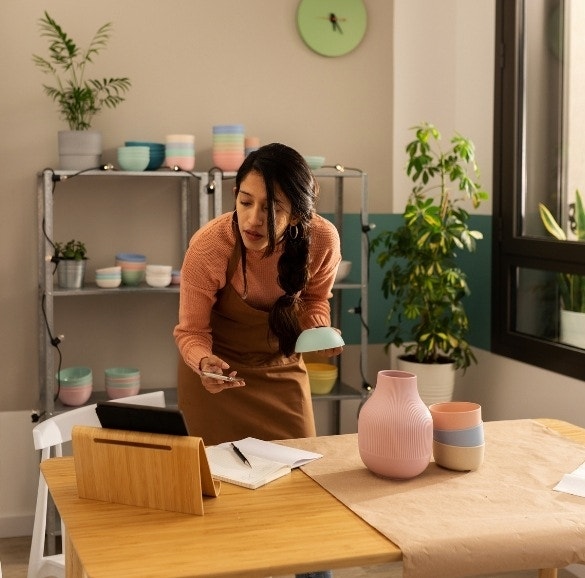 A freelance pottery maker editing the PDF sell sheets of their new pottery products in Adobe Acrobat