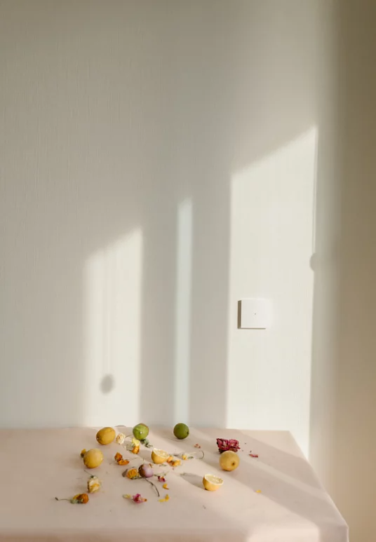 Lemons, limes, and flower petals artistically placed on a table