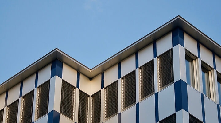 A building with numerous windows and a clear blue sky behind it