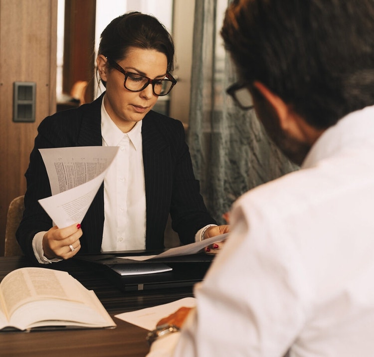 Two people sitting at a table together reviewing legal memos