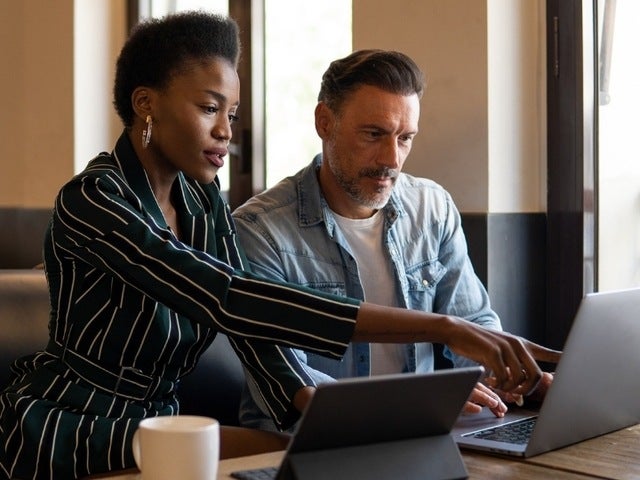 Two workers looking over their company's systems of agreement to update how they prepare, sign, enact, and manage them