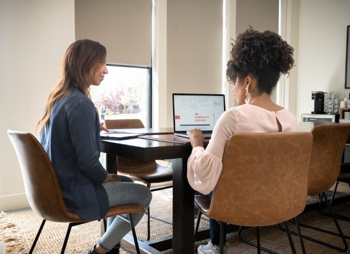 A photo of a borrower and a lender discussing an earnings report.