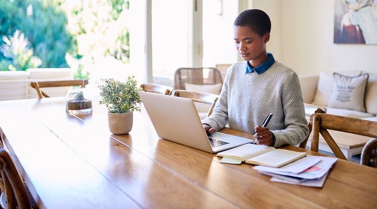 A business owner at their desk reviewing a loan agreement with their laptop