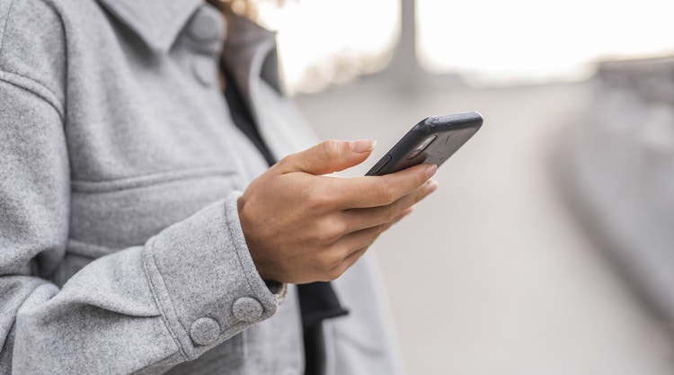 A person holding a mobile phone in their hand while providing an s-signature on a digital document