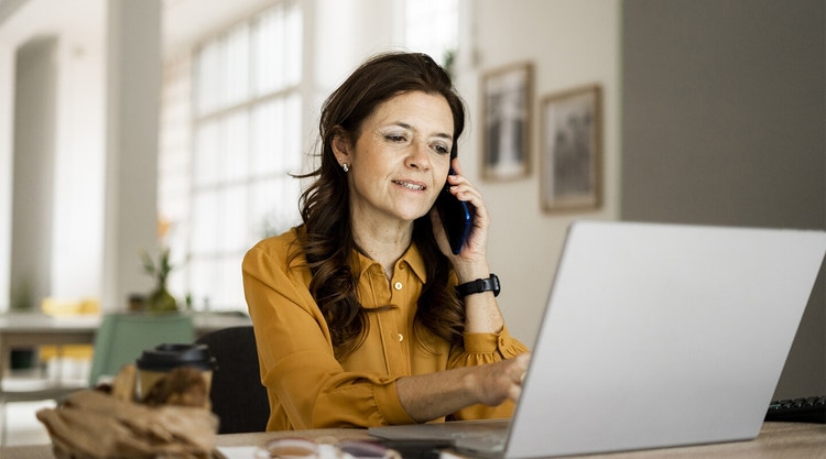 A businessperson discussing their sales process with a colleague by phone