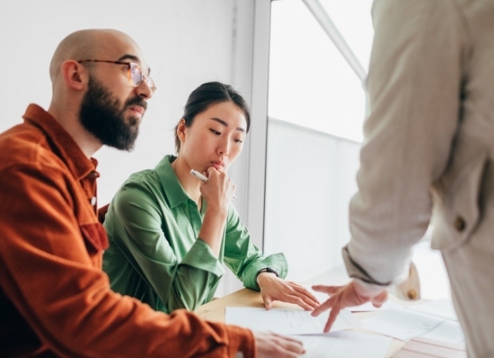 A photo of two borrowers talking to a lender about a collateral loan.