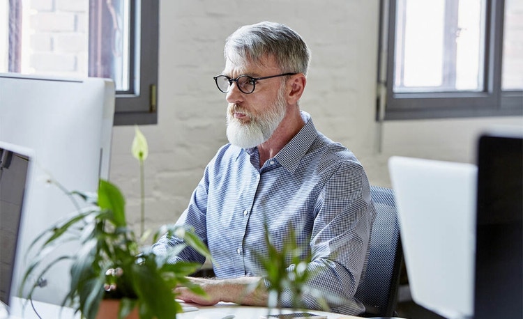 A person sitting in an office reviewing an affidavit on their monitor